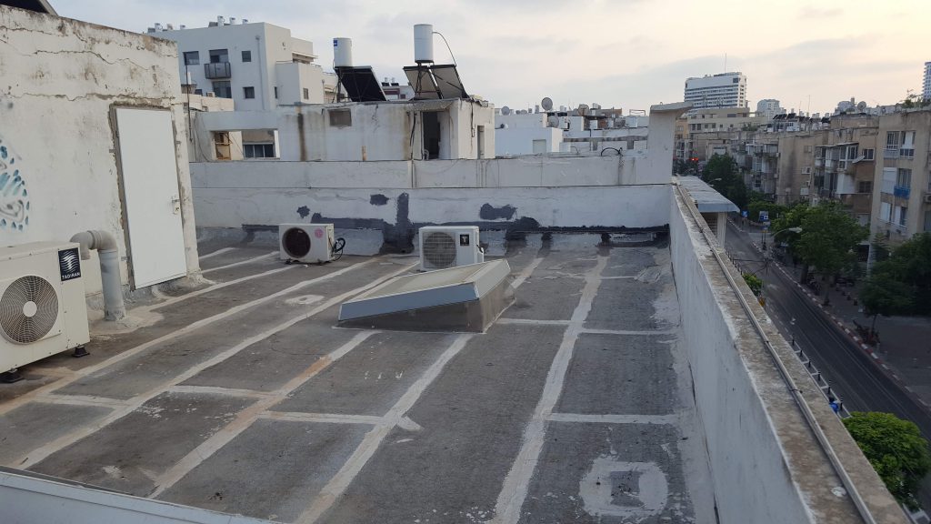 יריעות ביטומניות חשופות לשמש בגג בניין טיפוסי בתל אביב (ספטמבר 2020)