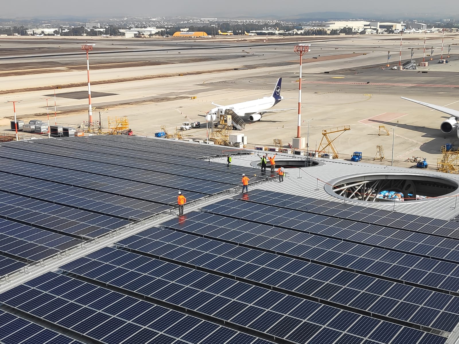 עובדי חברת קדמה סולארי מתקינים מערכת על גג טרמינל, נתב"ג