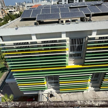 מערכת הצללה מסוג כנף מטוס מותקנת בזווית קבועה אופקית על מבנה חינוך. תמונה: יוניקיט